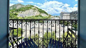 A balcony with a wrought iron railing overlooking a cityscape, including buildings and a hill with greenery. - Le Bastille / 6 pers / 300 m station / Air-conditioned (Grenoble)