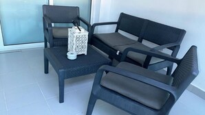 Een aantal donkere stoelen en een kleine tafel met een witte decoratie, staand op een betegelde vloer.