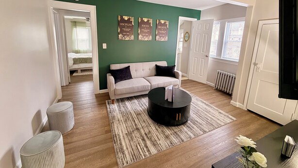 Ein Wohnzimmer mit Sofa, Couchtisch, Teppich und einer Wand mit motivierenden Postern.