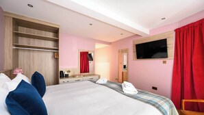 A hotel room with a large bed, a wardrobe with shelves, a flat-screen TV mounted on the wall, and a red curtain. - Deluxe Double with Courtyard View (Room 4 - Lower Ground Floor) (Edinburgh)