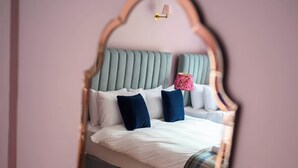 A bed with a grey upholstered headboard, white bedding, and a plaid throw blanket. - Deluxe Family Room (Room 12 - First Floor) (Edinburgh)
