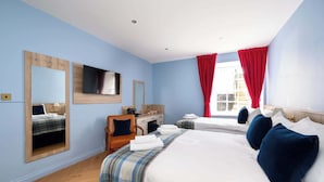 Une chambre d’hôtel avec deux lits, un bureau et une chaise.