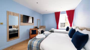 A hotel room with two beds, a desk, and a chair.