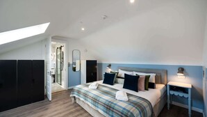 A bedroom with a bed, bedside tables, a mirror, and a wardrobe. - Luxury Studio Apartment (4th Floor - Room 15) (Edinburgh)