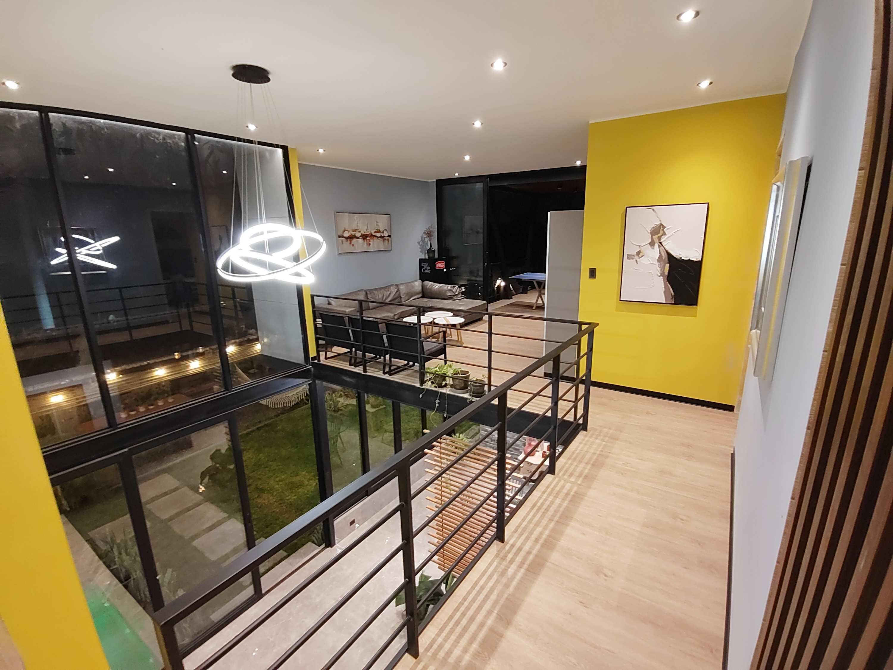 Un espace de vie moderne doté d’un balcon, d’un coin repas et d’un mur d’accent jaune.