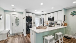 A modern kitchen with white cabinets, a central island, and a built-in oven. - Coastal Vibes & Community Amenities Await You! (Hilton Head Island)