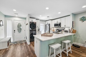 A modern kitchen with white cabinets, a central island, and a built-in oven. - Coastal Vibes & Community Amenities Await You! (Hilton Head Island)