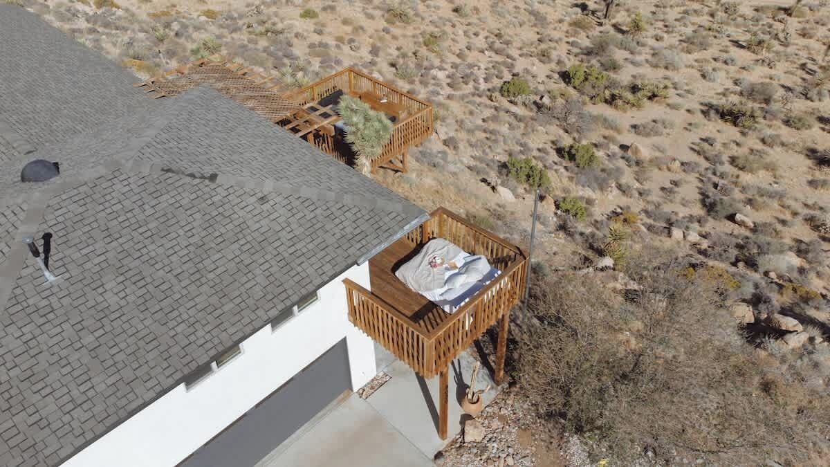 Une maison avec un toit en pente et une petite terrasse.