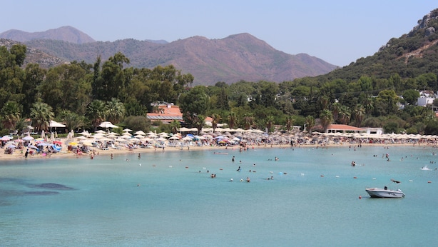 A beach with clear turquoise water, umbrellas, and people. - Detached Single - Storey Stone house in Datça Karaincir - Karaincir Houses 1 (Datça)