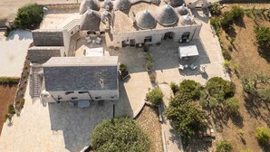 Vue aérienne d’un bâtiment doté d’une cour intérieure, de plusieurs structures en forme de dôme et d’espaces aménagés pour s’asseoir à l’extérieur.