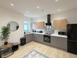 Een koelkast met diepvriezer, een microgolfoven, een oven, een kookplaat