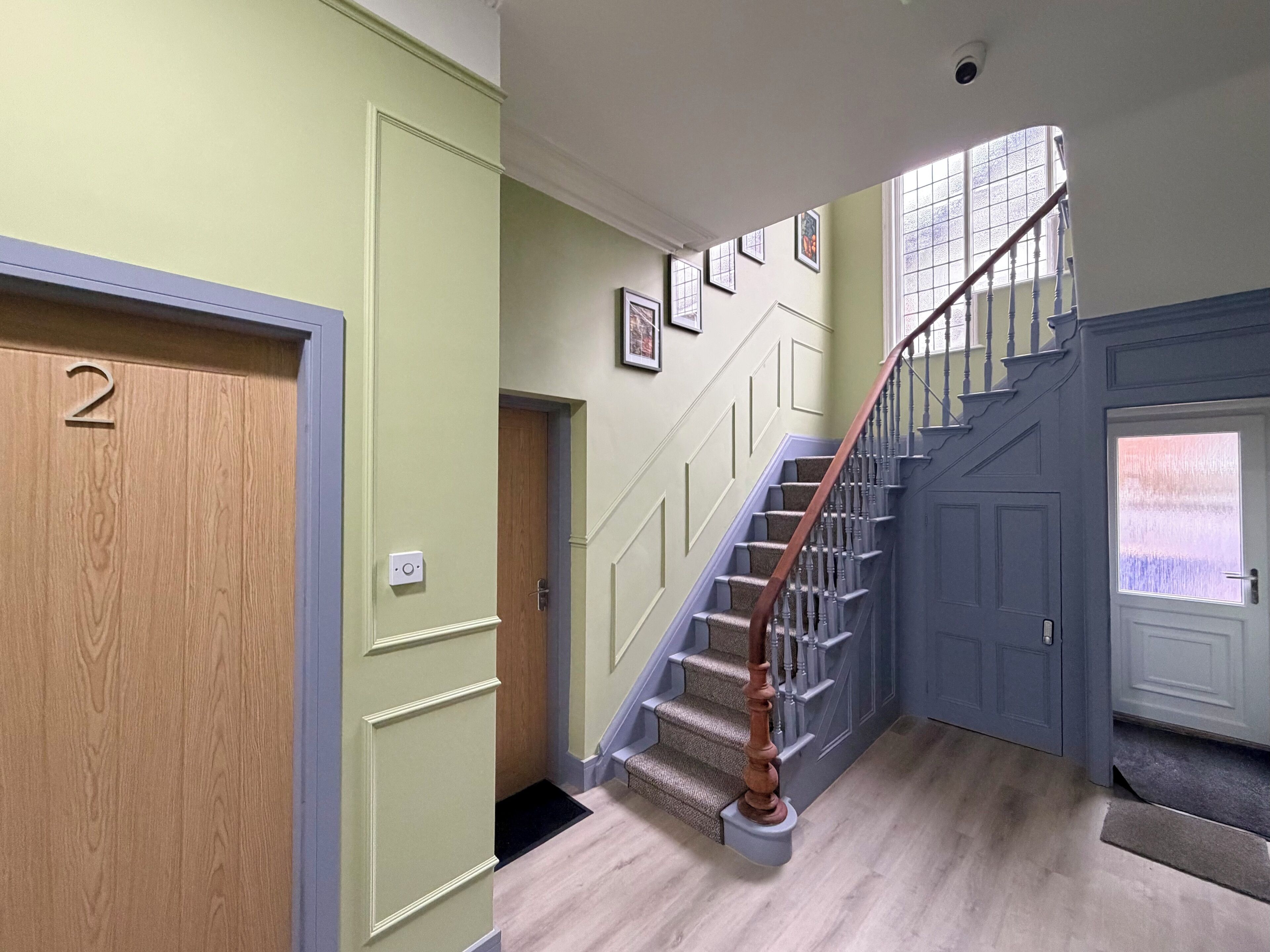 A staircase with wooden handrails and a carpeted landing.