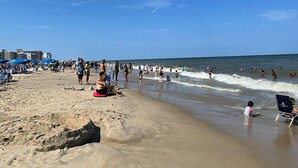 A crowded beach with people swimming and sunbathing. - Rehoboth 2BR Condo Near Beach & Boardwalk (Rehoboth Beach)