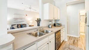 A modern kitchen with white cabinetry, stainless steel appliances, and a built-in dishwasher. - Rehoboth 2BR Condo Near Beach & Boardwalk (Rehoboth Beach)