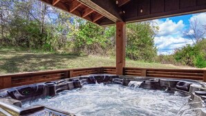Un jacuzzi con terraza de madera y vistas a zona boscosa.