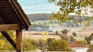 A table set outdoors with a view of a pool and countryside. - La Blanchie Haute, Gîte de charme d'exception pour 2 en Vallée de la Dordogne (Martel)