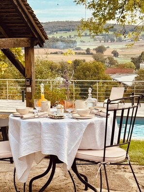 Ein Tisch im Freien mit Blick auf Pool und Landschaft.