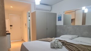 A modern hotel room with a bed, a wardrobe, a mirror, and an air conditioning unit. - A 2  minutos do Mar  02PP by La Playa (Ipojuca)