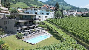 A modern hotel with a pool, surrounded by vineyards and hills. - Holiday Apartment ‘Erbacher – Gabi’s Suite’ with Mountain View, Sauna and Pool (Bozen)