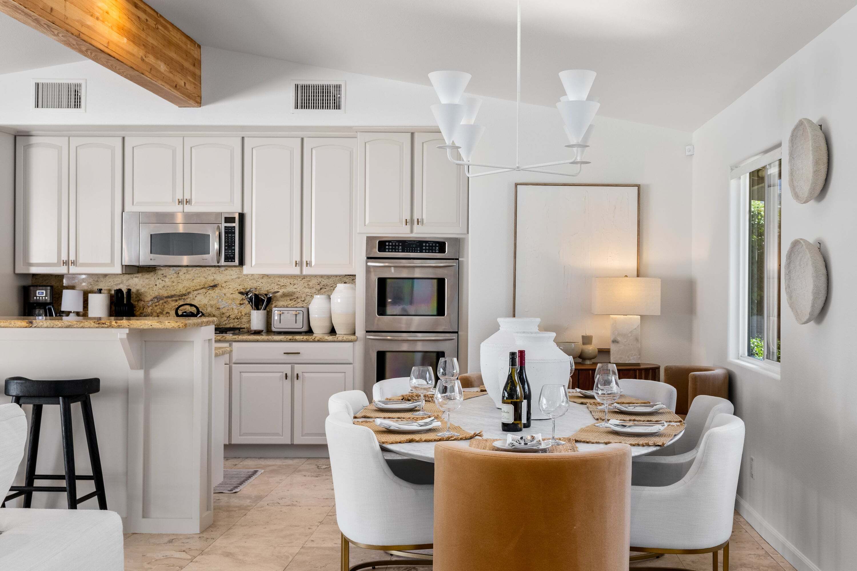 A modern kitchen with white cabinets, a granite countertop, a built-in microwave, and a large oven.