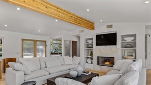 Ein modernes Wohnzimmer mit einem weißen Sofa, einem Couchtisch und einem Kamin.