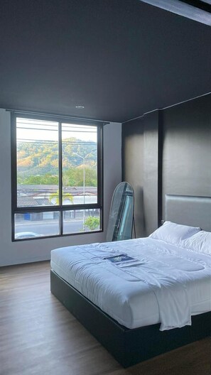 A modern bedroom with a large window, a bed, and a mirror. - The Atrium Kathu (Kathu)
