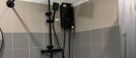A shower area with a handheld showerhead, a wall-mounted control panel, and a shower curtain.