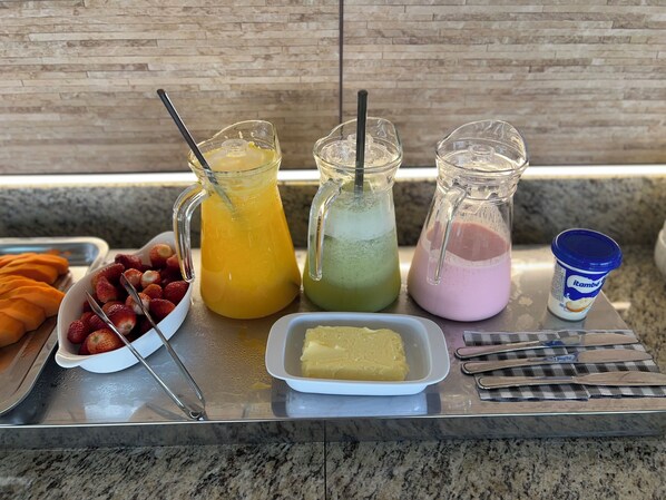 A buffet table with various food items and drinks. - Pousada Verde Serrath (Mangaratiba)