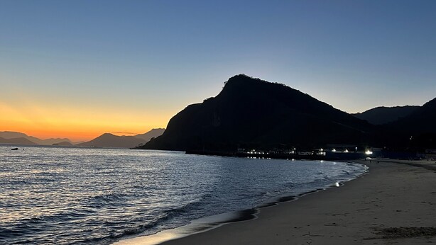 A beach with a mountain in the background and a crescent moon in the sky. - Pousada Verde Serrath (Mangaratiba)