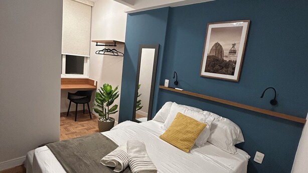 A bedroom with a bed, a desk, and a chair. - 2 quartos 650m praia de Ipanema (Rio de Janeiro)