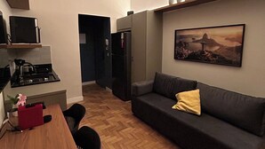 A modern living room with a sofa, a dining table, and a ceiling fan. - 2 quartos 650m praia de Ipanema (Rio de Janeiro)