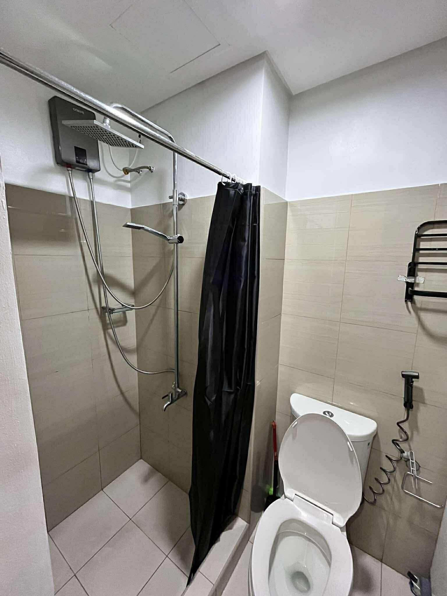 Un baño pequeño con ducha, inodoro y un perchero para toallas.