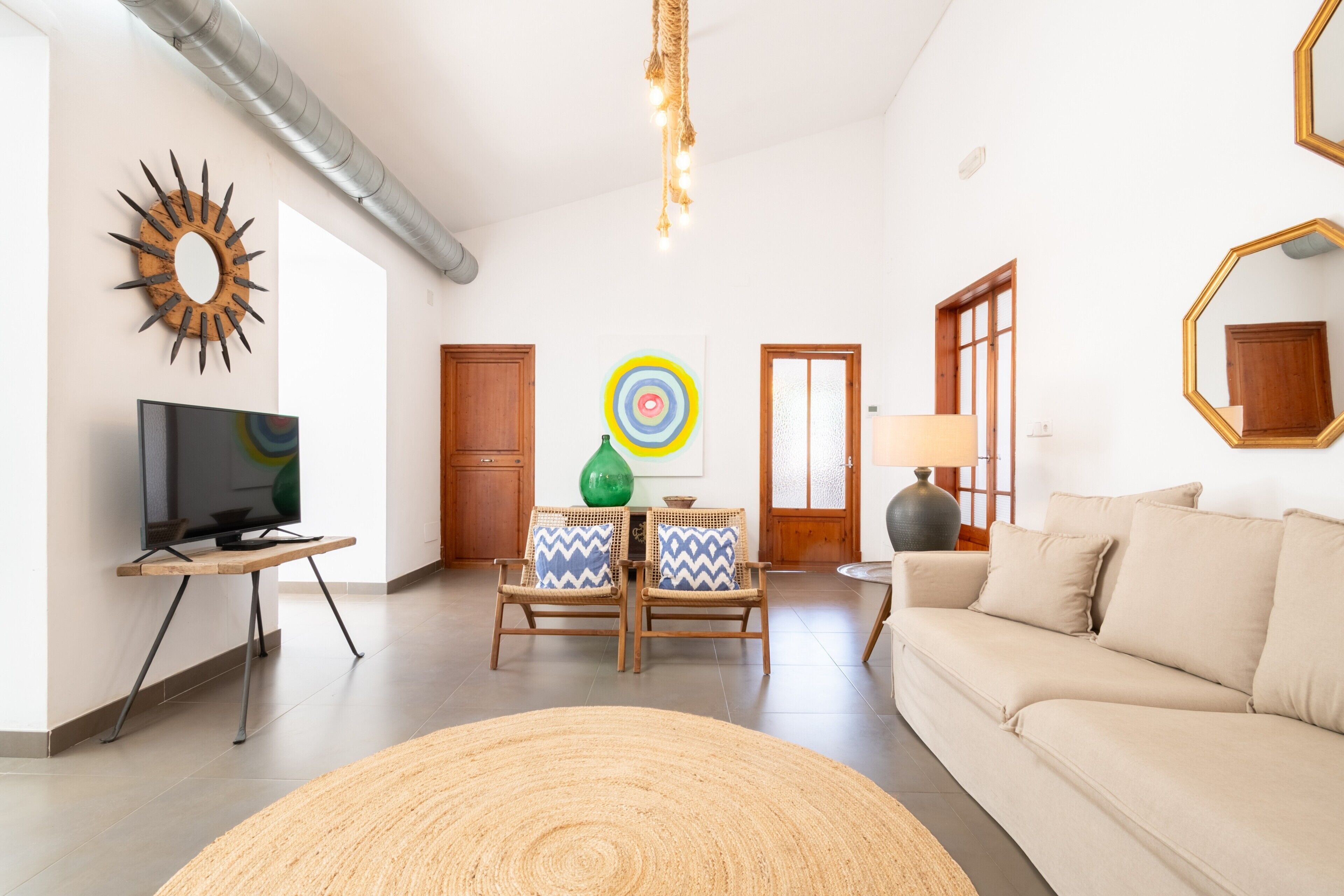 A living room with a sofa, a television, a coffee table, and a decorative wall piece.