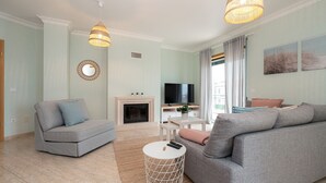 Ein modernes Wohnzimmer mit Kamin, Flachbildfernseher und gemütlicher Sitzecke.