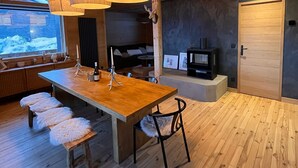 Een modern interieur met een houten eettafel, banken en hanglampen.