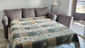 A bedroom with a bed, a window, and a wall decoration. - Cozy 1-bedroom condo in serene Oak Harbor with AC and private dock to Lake Erie (Oak Harbor)