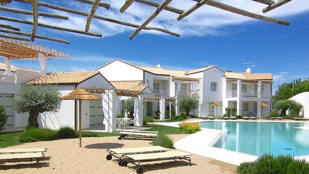 A resort with a swimming pool, sun loungers, and a covered seating area. - Les Maisons B12 - Carraro Immobiliare Jesolo (Lido di Jesolo)