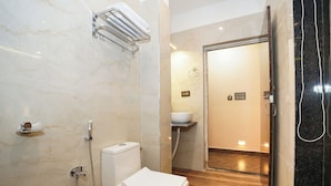 A modern bathroom with a toilet, shower, and sink. - See Pearl (Kanthi)