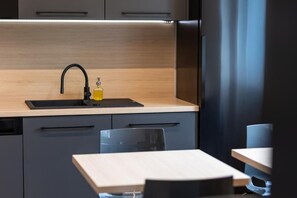 Appartement Deluxe, vue cour intérieure | Cuisine privée | Grand réfrigérateur, micro-ondes, four, plaque de cuisson
