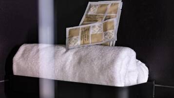 Un banco blanco acolchado con un atril para revistas frente a una pared oscura.