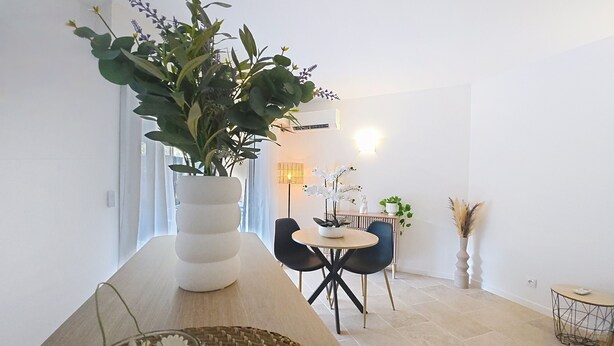 A modern dining area with a white vase, a round table, and two chairs. - Cosy garden-floor studio - Sun & beach on foot (Golfe-Juan)