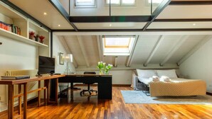 A loft-style bedroom with a wooden desk, a bed, and a skylight. - Casa Pegaso in Canton de Fiori (Bologna)