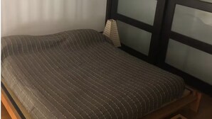 A bed with a striped mattress and a wooden frame. - Celeste sea view vacation home with parking (Portici)