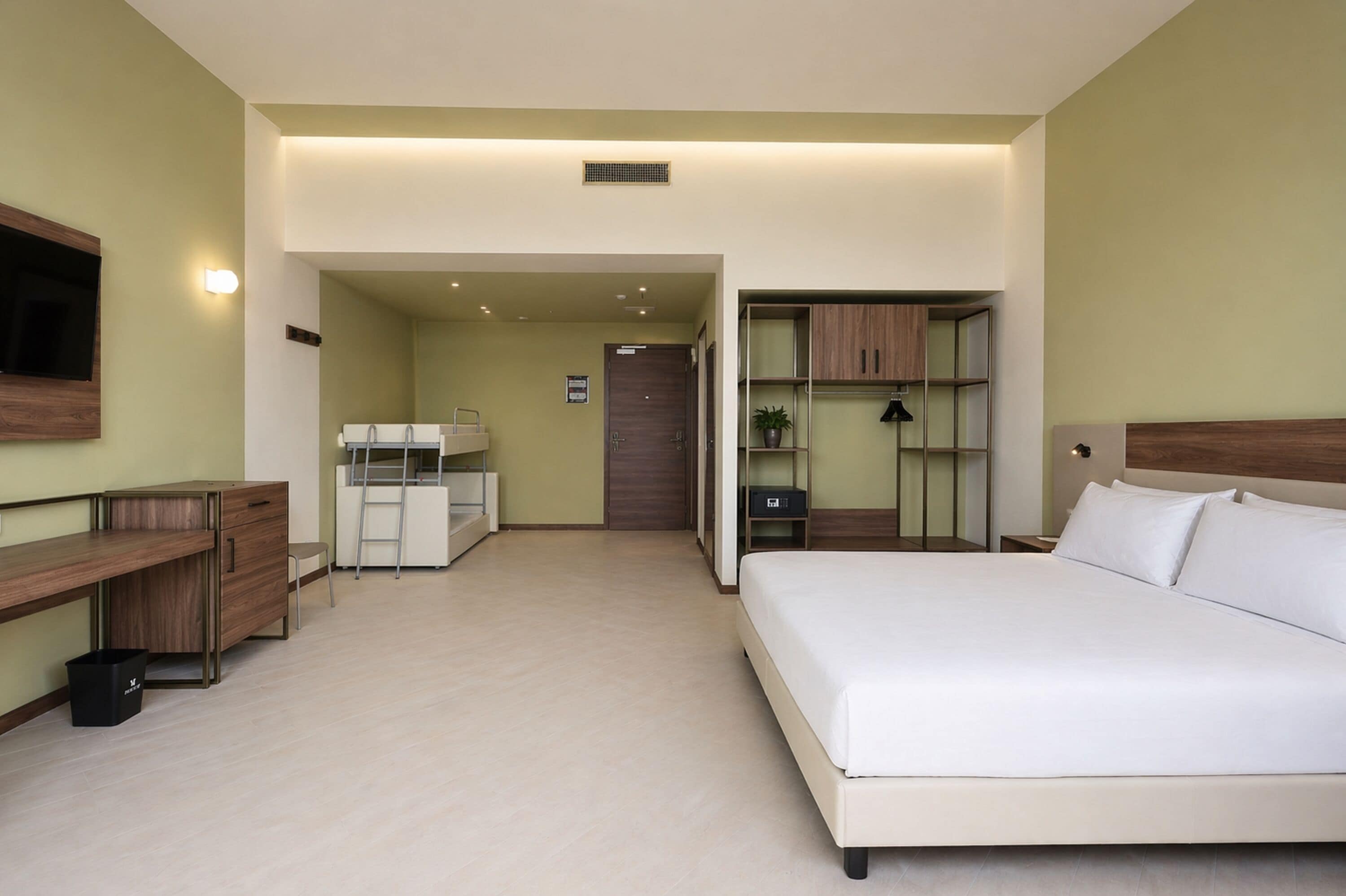 Une chambre d’hôtel équipée d’un lit, d’un bureau, d’une armoire et d’une petite kitchenette.