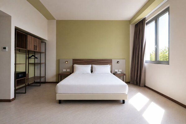 Une chambre d’hôtel moderne avec un grand lit, une armoire, une table de chevet et une fenêtre avec des rideaux.