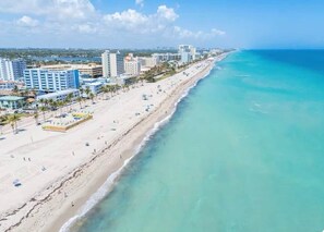 A coastal cityscape with a wide beach, high-rise buildings, and clear blue waters. - The Emerald Palms Tropical Beach Villa (Hollywood)