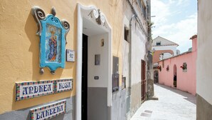 A narrow street with a building entrance, a doorbell, and a nameplate reading "Andrea Rosa." - Barbera House (Positano)