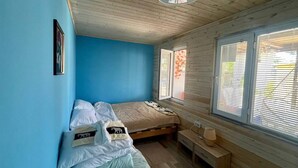 Una camera da letto con un letto, un comodino e una finestra con persiane.