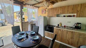 Una cucina rustica con mobili in legno, un tavolo da pranzo apparecchiato per quattro persone e vista sull'esterno.