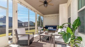 A covered patio with outdoor furniture, a ceiling fan, and a potted plant. - Masters Week Stay in Bartram Trail Golf Community! (Evans)